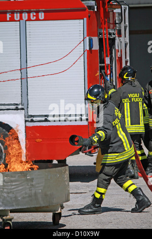 italienischen Feuerwehrleute löschen einen simulierten Brand während einer Übung in der Feuerwache Stockfoto