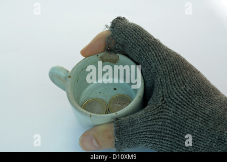 eine schlechte Hand eine Tasse mit Route in das Euro-Geld Stockfoto