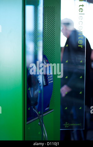 Telefonzelle im Internationalen Flughafen mit einem Mann in der Ferne Stockfoto