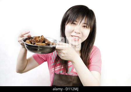 Chinesin mit geschmortes Hähnchenflügel Stockfoto