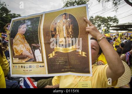 5. Dezember 2012 hält - Bangkok, Thailand - eine Frau ein Bild des Königs auf der Royal Plaza Mittwoch während sie wartet, Bhumibol Adulyadej, der König von Thailand, vor seinem Publikum auf dem Mukkhadej Balkon Ananta Samakhom Throne Hall zu sehen. 5 Dezember ist ein nationaler Feiertag. Es ist auch als Vatertag gefeiert. Feierlichkeiten sind landesweit anlässlich des Geburtstags von Bhumibol Adulyadej, der König von Thailand statt. (Bild Kredit: Jack Kurtz/ZUMAPRESS.com ©) Stockfoto