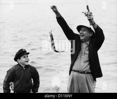 1950S 1960S JUNGE SOHN ANGELN MIT MANN VATER ODER GROßVATER HOLDING UP FISCH AUF LINIE LACHEN SPASS HABEN Stockfoto