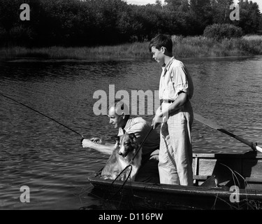 1930ER JAHRE MANN VATER TEENAGER SOHN HUND IM RUDERBOOT ANGELN IM TEICH Stockfoto