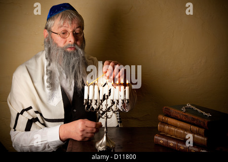 Alter jüdischer Mann mit Bart Anzünden von Kerzen für Hanukkah Stockfoto