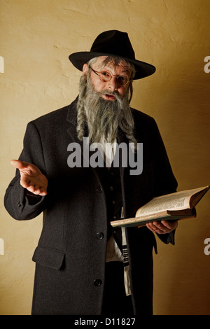 Alter jüdischer Mann mit grauem Bart, der ein Buch hält Stockfoto