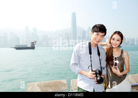 Glückliches junges Paar mit SLR-Kamera im Victoria Harbour, Hongkong Stockfoto