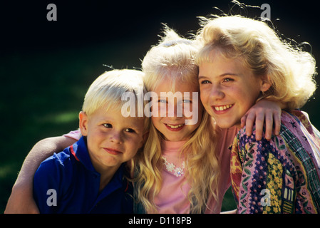 1980S 1990S PORTRAIT EINES JUNGEN UND ZWEI MÄDCHEN IM FREIEN Stockfoto