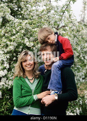 1970ER JAHRE FAMILIE IM FREIEN MUTTER UND VATER MIT SOHN AUF SCHULTERN Stockfoto