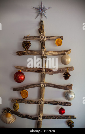 Treibholz-Weihnachtsbaum gemacht Formsteine Treibholz am Strand und Zeichenfolge gefunden. Stockfoto