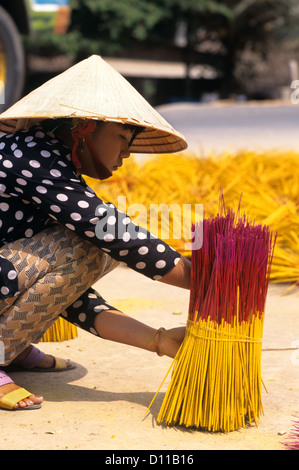 1990ER JAHRE MEKONG VIETNAM FRAU BÜNDELUNG WEIHRAUCH IM MARKTPLATZ Stockfoto