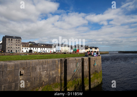 Junge Menschen, die entspannen, The River Corrib fließt zwischen den Long Walk und Claddagh Quay, Stadt Galway, Irland Stockfoto