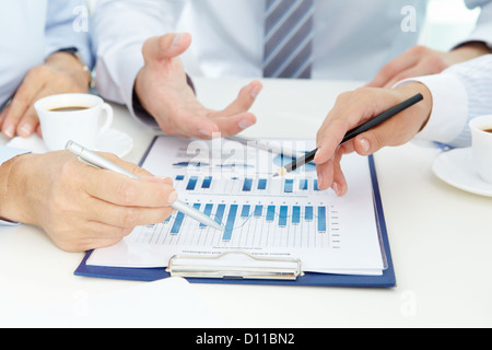 Bild von Menschenhand mit Stiften über geschäftliche Dokumente der Tagung Stockfoto