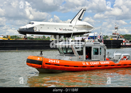 Küstenwache Boot Besatzung von Station New York erzwingt eine Sicherheitszone um ein Lastkahn, der pensionierte Space Shuttle Enterprise zu tragen, während es durch den Hafen von New York, das Intrepid Sea, Air and Space Museum 6. Juni 2012-Transite. Stockfoto