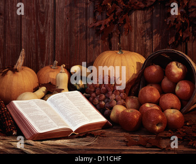 BIBEL OFFEN FÜR PSALMEN UND ERNTE KORB MIT ÄPFELN KÜRBISSE TRAUBEN UND BLÄTTER IM HERBST Stockfoto