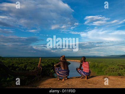 Karo-Stamm Männer hocken über der Omo-Fluss, Korcho Dorf, Omo-Tal, Äthiopien Stockfoto