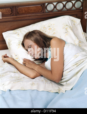 1970ER JAHREN FRAU IM BETT SCHLAFEN AUF IHRER SEITE Stockfoto