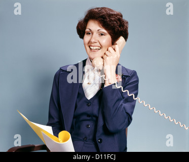1970ER JAHREN LÄCHELND BUSINESS FRAU AM TELEFON RETRO Stockfoto