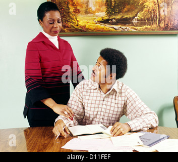 1970ER JAHREN AFRIKANISCHE AMERIKANISCHE PAAR MANN FRAU TISCH GEHEN ÜBER HAUSHALTSKONTEN SCHECKHEFT PERSÖNLICHE FINANZEN Stockfoto