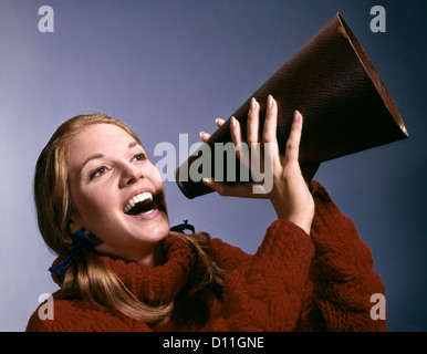 1960ER JAHRE PORTRAIT TEEN CHEERLEADER MÄDCHEN SCHREIEN IN MEGAPHON Stockfoto