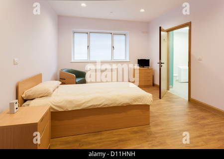 Unbesetzten Pflege zuhause Schlafzimmer mit offener Tür, En-Suite Badezimmer. Stockfoto