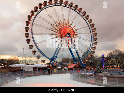 Eis-Eisbahn und Riesenrad an einen traditionellen Weihnachtsmarkt am Abend am Alexanderplatz, Berlin, Deutschland Stockfoto
