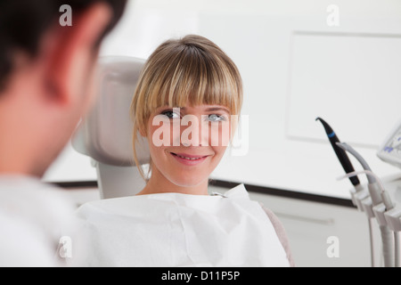 Deutschland, junge Frau im Zahnarztstuhl, Lächeln Stockfoto