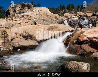 Kinder klettern am Schuttkegel Wasserfall. Stockfoto