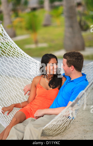 Ein Mann und eine Frau sitzen zusammen In einer Hängematte auf Bora Bora Nui Resort & Spa; Insel Bora Bora, Gesellschaftsinseln, Südpazifik Stockfoto