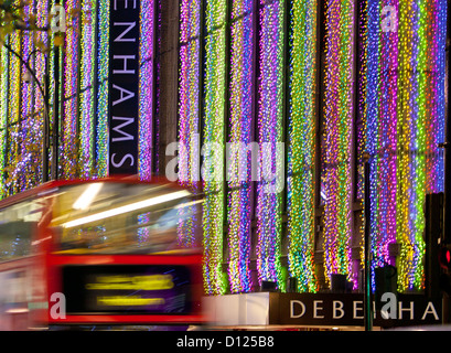 Red London Bus vorbei Kaufhaus Debenhams auf der Oxford Street mit Weihnachtsbeleuchtung in der Nacht London England UK Stockfoto