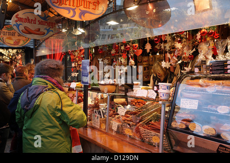 Menschen kaufen Lebensmittel an einem Marktstand auf dem Weihnachtsmarkt in Birmingham-UK Stockfoto