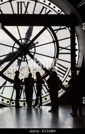 Eine Gruppe von Menschen, die mit Blick durch die Riesenuhr in Musee d'Orsay, Paris, Ile-de-France, Frankreich, silhouettiert wurden Stockfoto