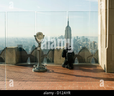 Eine Person mit Blick nach Süden, die ein Foto des Empire StateBbuilding vom Top of the Rock in Midtown Manhattan machte. Stockfoto