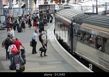 Menschen warten auf ein East Coast Main Line Bord Zug am Bahnhof von York, England. Stockfoto