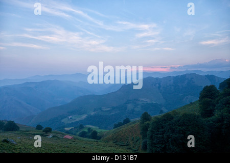 Ein leicht rosafarbener Morgenhimmel über den nebligen Pyrenäen auf der französischen Route des Jakobsweges nach Santiago de Compostela. Stockfoto