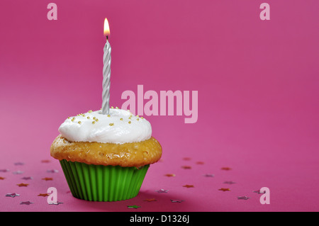 Geburtstag Kuchen mit Schlagsahne und Kerze auf rosa Hintergrund Stockfoto