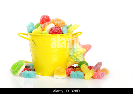 Bunte Bonbons in gelben Eimer isoliert auf weißem Hintergrund Stockfoto
