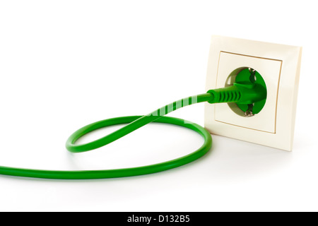 Grüner Stromstecker in Steckdose vor einem weißen Hintergrund Stockfoto