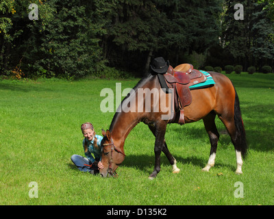 Schöne Mädchen und ihrem hübschen Pferd auf der Weide Stockfoto