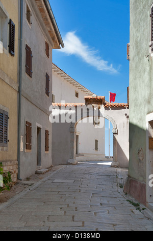 Visnjan Architektur. Istrien, Kroatien. Schmale Straße und Stadt Tor gekrönt mit einem venezianischen Löwen und ein offenes Buch. Stockfoto