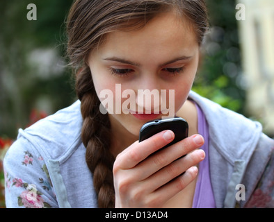 Mädchen mit einem Mobiltelefon liest die Nachricht Stockfoto