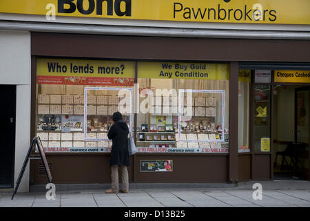 6. Dezember 2012. London UK. Eine Frau schaut Wndow von einem Pfandleiher Shop in Clapham. Der Kanzler des Finanzministeriums war gezwungen, zuzugeben, dass die britische Wirtschaft schrumpft weiter während seiner Herbst Haushalt Erklärung an Parlament und eine wirtschaftliche Erholung dauert länger als erwartet Stockfoto