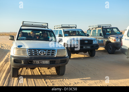 Off Road Autos für mit Touristen fahren auf Wüste Sahara. Frontansicht in Bewegung. Chebika, Tunesien, Afrika. Menschen sitzen in Fahrzeugen Stockfoto