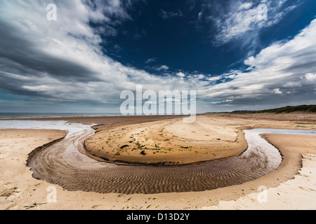 Ein Stream In eine Runde Form In den Sand entlang der Küste gebildet; Druridge Bay Northumberland England Stockfoto
