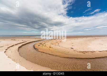 Ein Stream In eine Runde Form In den Sand entlang der Küste gebildet; Druridge Bay Northumberland England Stockfoto