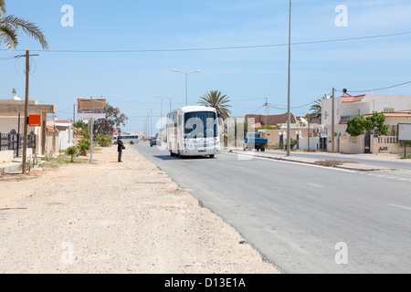 Die Strecke zwischen Tunesien und Libyen, Afrika. Der Weg durch die kleine Siedlung. Touristenbus führt Trog das Dorf Stockfoto