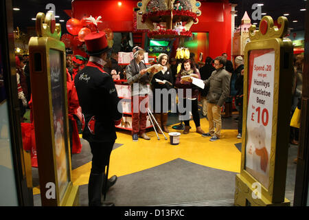 HAMLEYS CAROL SINGERS im STORE LONDON Weihnachtsbeleuchtung und Schaufenster LONDON ENGLAND UK 6. Dezember 2012 Stockfoto