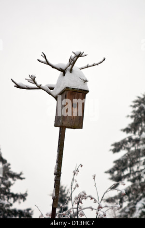 Alte hölzerne Vogelhäuschen Schnee bedeckt Stockfoto