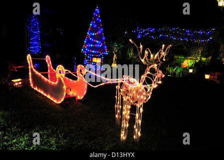 Reading, UK. 6. Dezember 2012. Weihnachtsschmuck im Vorstadthaus mit Nicken, Rentiere und eine Weihnachtsbotschaft aktiviert indem man Busse und Fußgänger entwerfen und Gartengestaltung begann im Oktober aber am 1. Dezember vor dem Schalten Licht hinter dem Haus, wie gesehen von Gemeinderat durfte, rundet das Wunderland mit Rentier als nicken Stockfoto