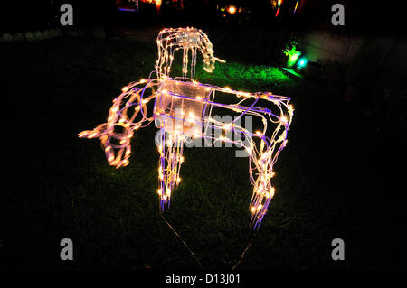 Reading, UK. 6. Dezember 2012. Weihnachtsschmuck in einem Vorstadthaus "mit Rentier und ein Weihnachtsfest Nachricht aktiviert, indem man Busse und Fußgänger entwerfen und Gartengestaltung begann im Oktober aber Dezember 1. vor erlaubt vom lokalen Rat, schalten Sie Licht vorne und Rückseite des Hauses rundet das Wunderland mit Nicken Rentier (wie gesehen) Stockfoto