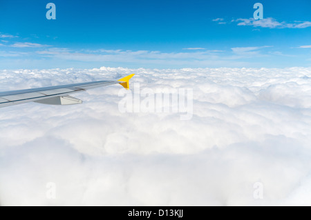 Blick aus dem Flugzeugfenster über den Wolken Stockfoto